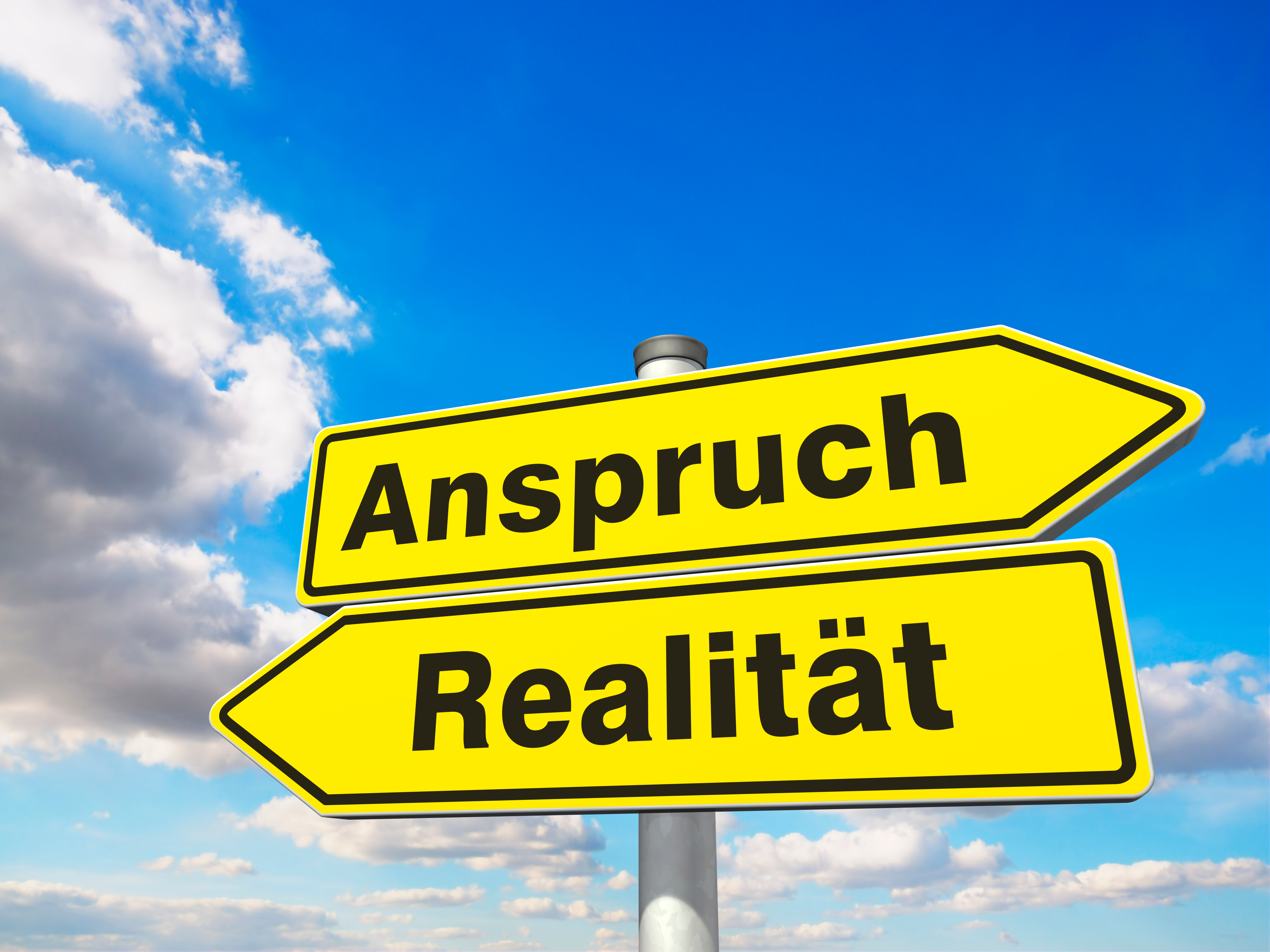 dieses Foto zeigt zwei Straßenschilder mit der Aufschrift "Anspruch" und "Realität"