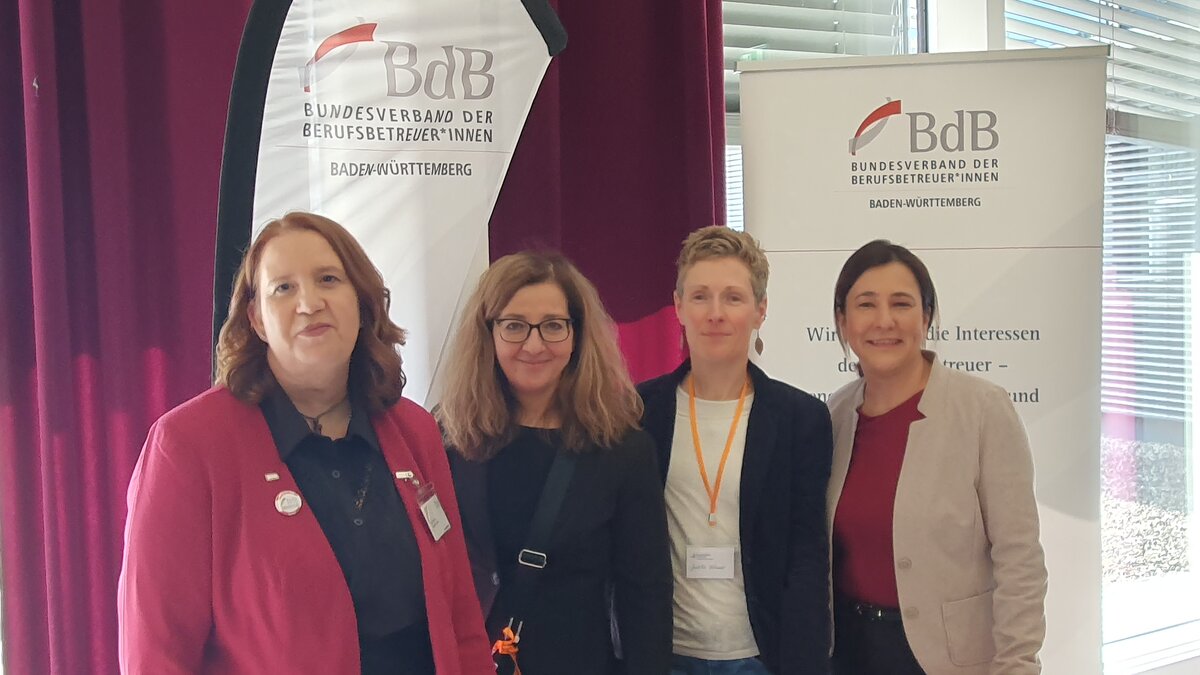 Auf diesem Foto sind 4 Personen vor einer BdB-Beachflag zusehen. 