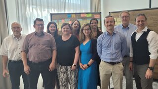 Auf diesem Foto sind zehn Personen auf einem Gruppenfoto zu sehen