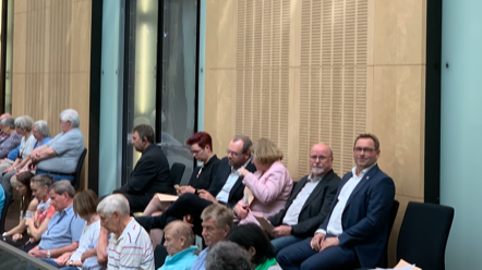 Menschen, die in einem Saal auf Stühlen sitzen 