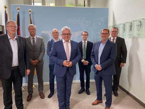 Dr. Harald Freter, Guido Wolf, Thorsten Becker. Hinten: Gerd Schmitt und das Team des Ministeriums